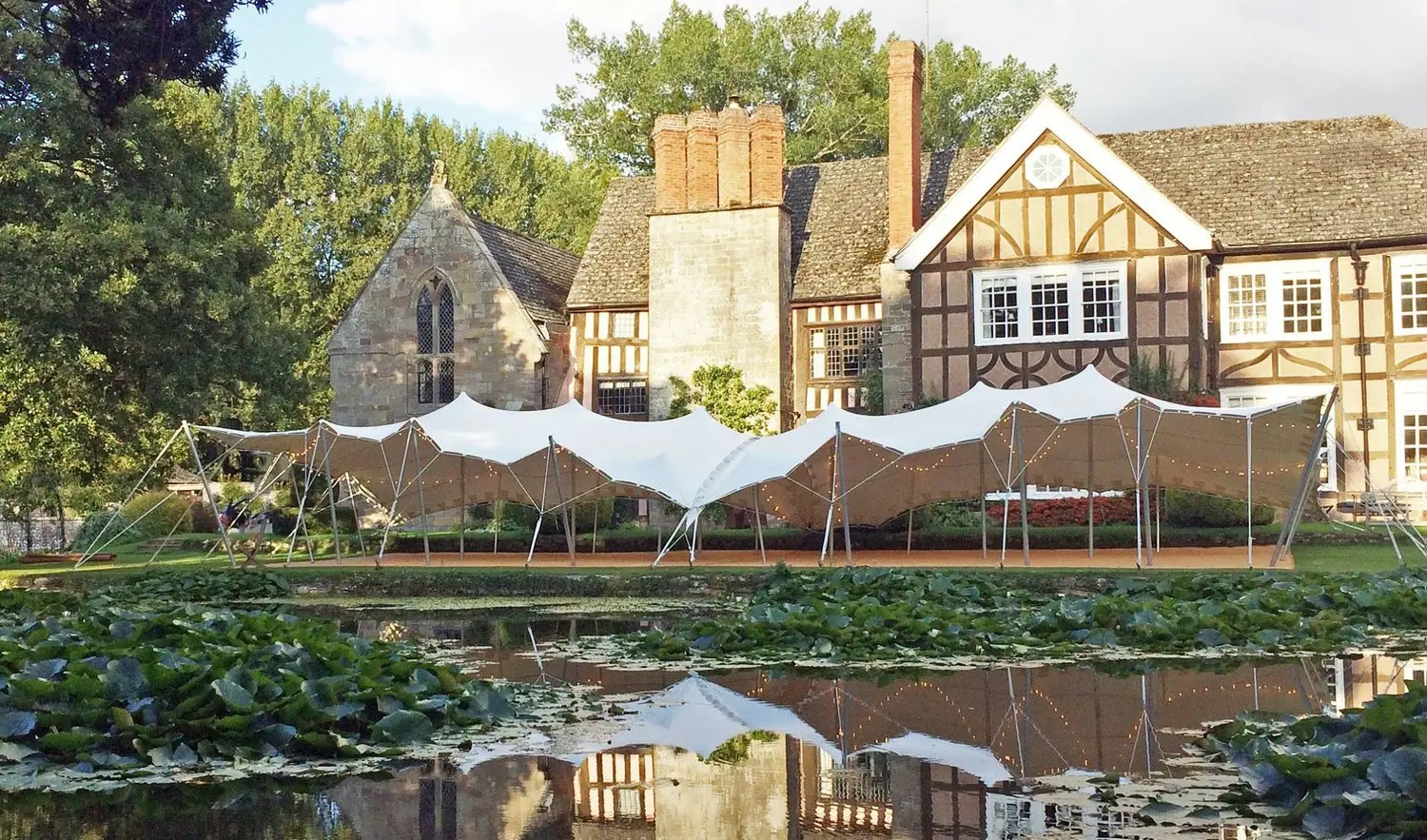 8x20m stretch tent beside a moated manor wedding venue - Freestretch stretch tent hire