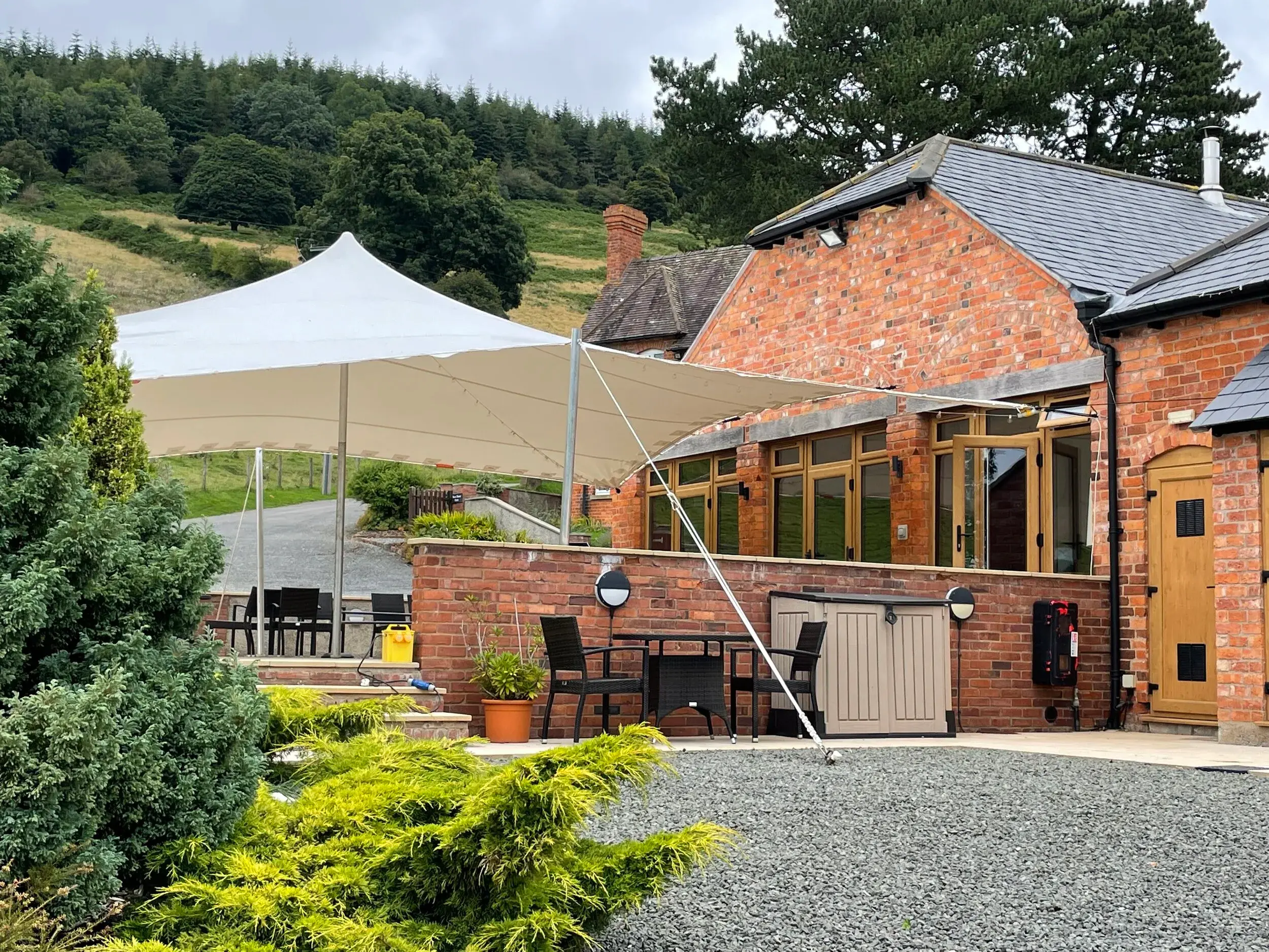 White stretch tent shading the courtyard of a brick barn venue