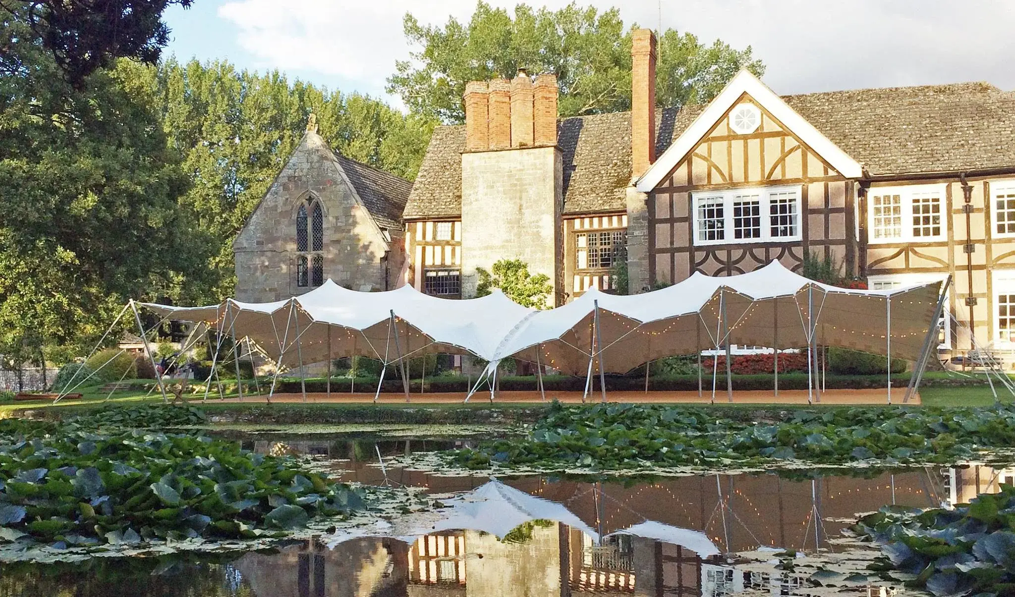 8x20m stretch tent beside the moat at Brinsop Court, Herefordshire - marquee hire Evesham